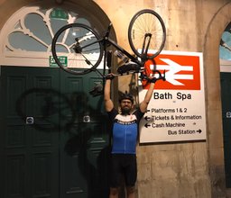 Bisher Diyani lifting his bike as he arrives in Bath